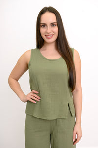 Woman wearing a green sleeveless top and pants on a white background