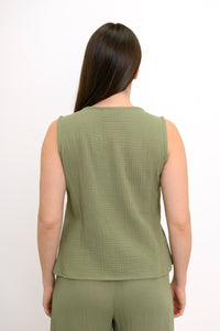 Woman wearing a green sleeveless top, wide-leg pants against, against a white background, back view