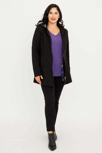 Model wearing The Highlands Coat open over a purple sweater and black pants