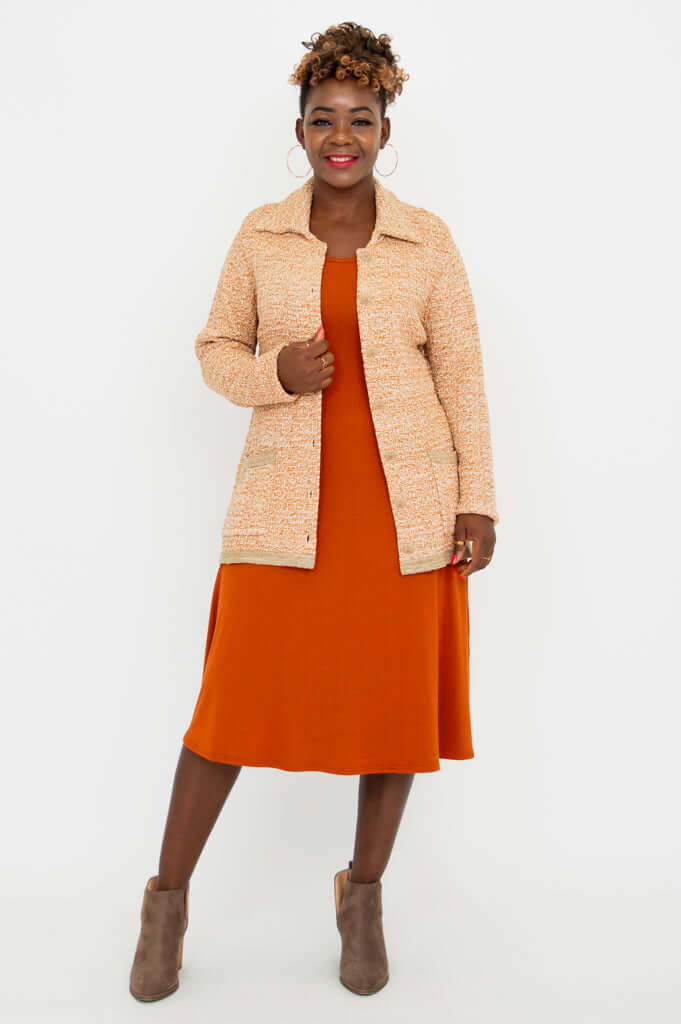 Full front view of model in Chanel Cardigan and orange dress with taupe ankle boots