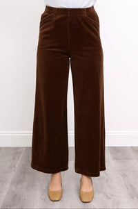 Close-up front view of woman wearing wide-leg chocolate colored pants in corduroy fabric