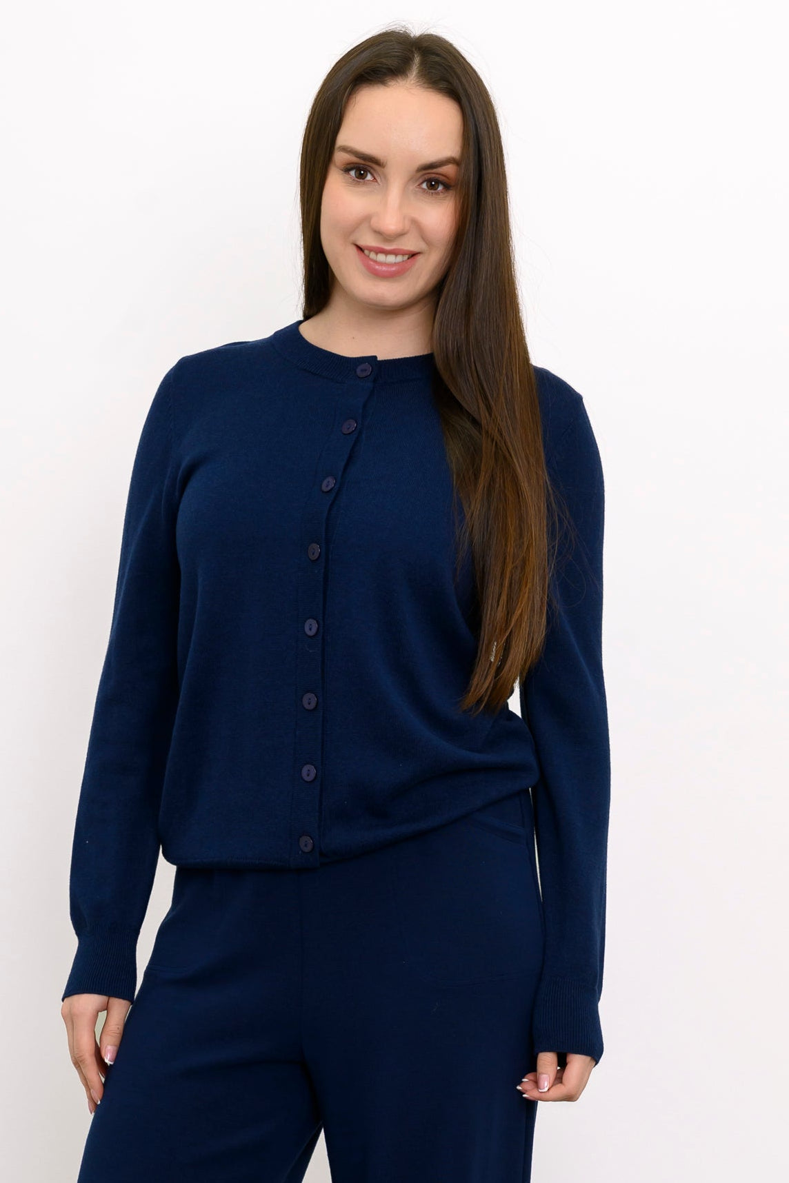 Close up front view of a woman wearing a navy blue crewneck button up cotton blend cardigan sweater.