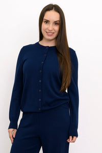 Close up front view of a woman wearing a navy blue crewneck button up cotton blend cardigan sweater.