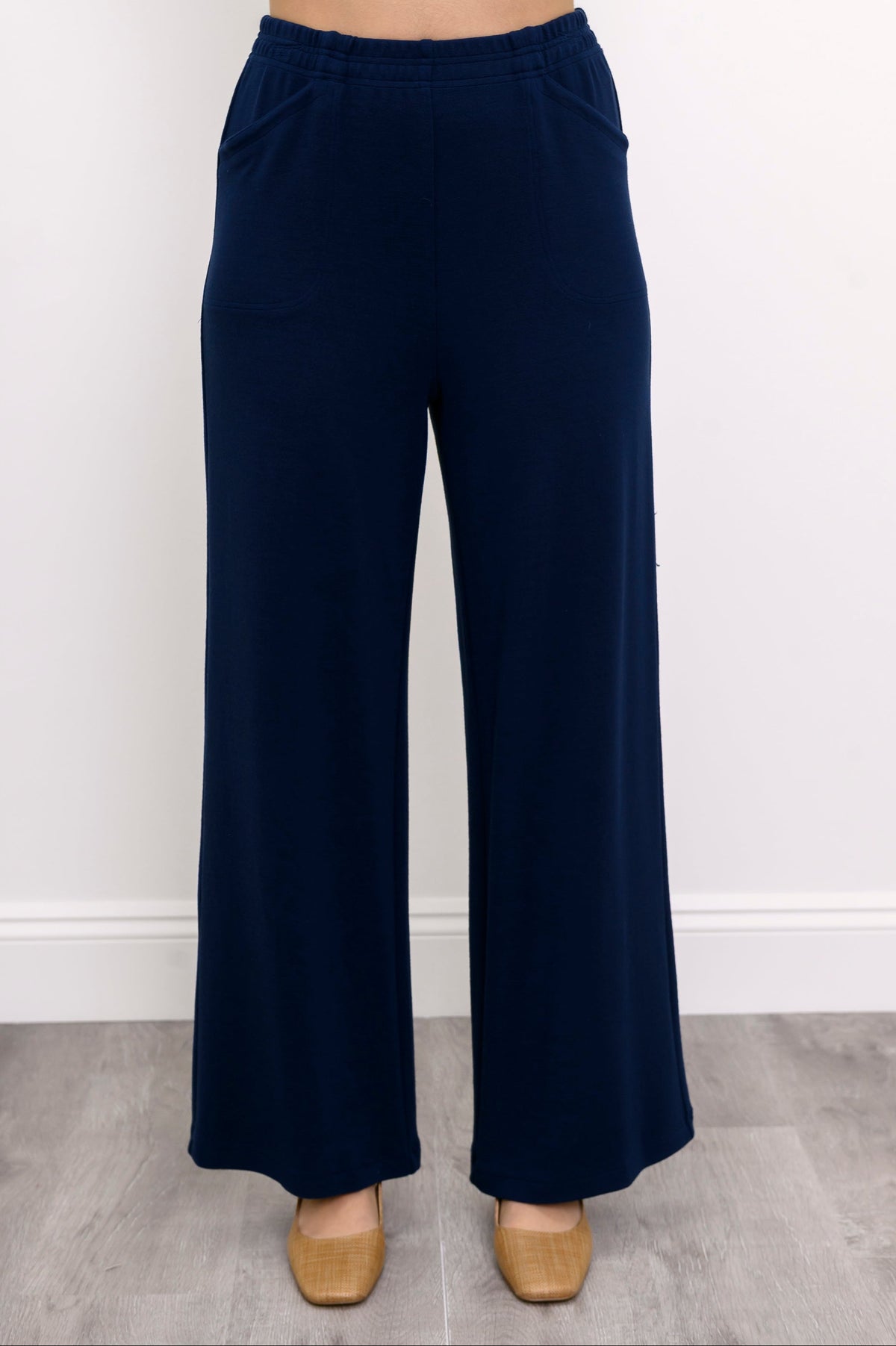 Close-up front view of woman wearing high-waisted pants with relaxed fit and pockets