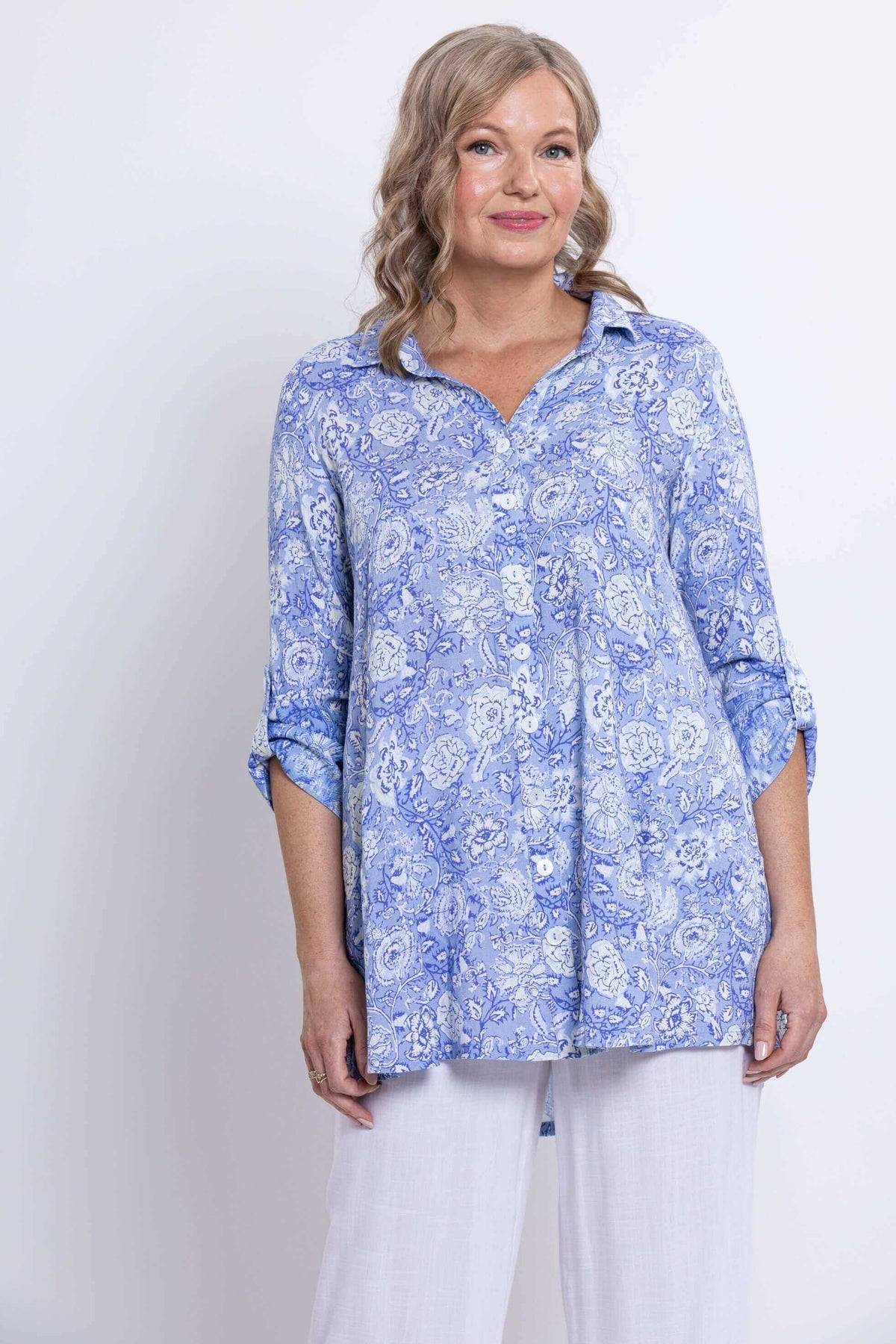 Woman in blue floral bamboo-linen tunic, partial body view