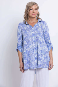 Woman in blue floral bamboo-linen tunic, partial body view