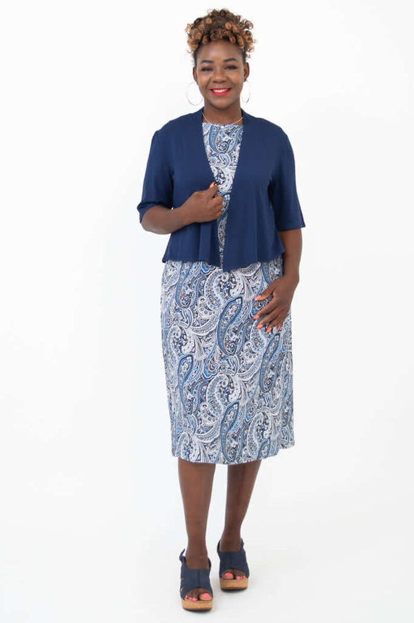 Woman in blue paisley shift dress with matching navy cropped jacket