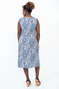 Back view of woman in blue paisley shift dress and navy sandals