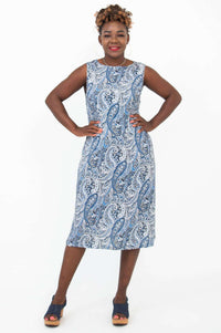 Confident pose in sleeveless blue paisley shift dress, front view