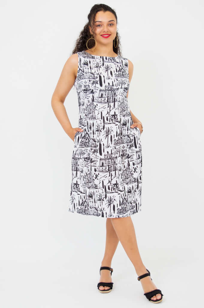 Woman standing with hands in pockets wearing Patricia black and white shift dress