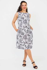 Woman standing with hands in pockets wearing Patricia black and white shift dress
