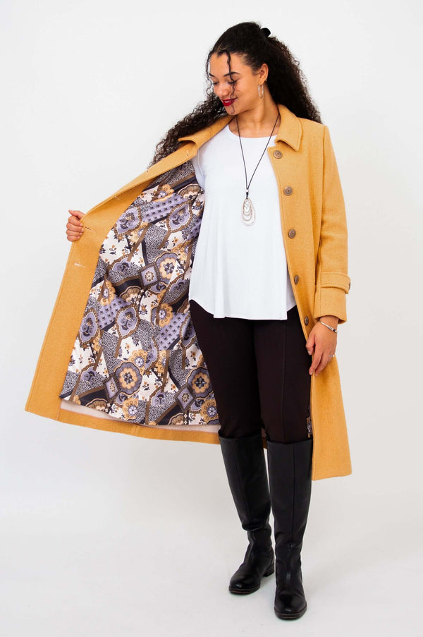 Model displaying the patterned inner lining of the Edna wool blend coat, worn open