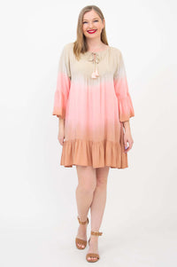 Front view of Ellie Dress in peach and blush gradient on a smiling model