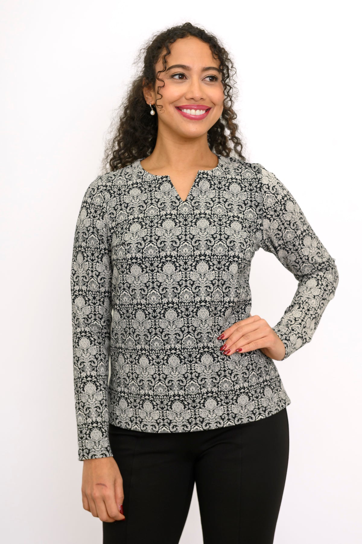 Women's long sleeve floral lace motif blouse with a notched neckline and straight hem.