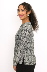 Profile angle of a straight-cut bamboo cotton blend floral print top with side slits.