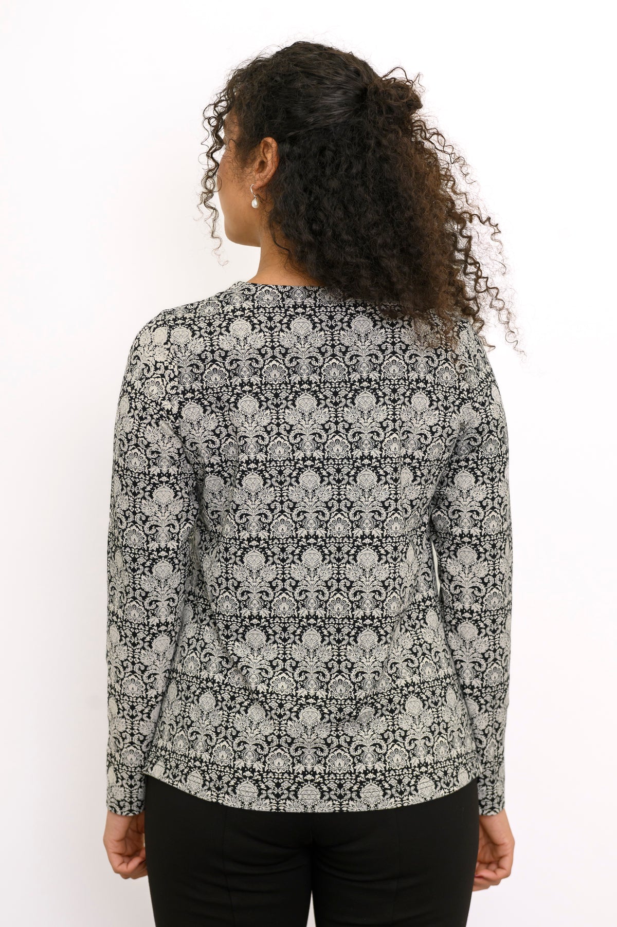 Rear view of a straight-cut bamboo cotton floral print blouse showing a clean draped back.