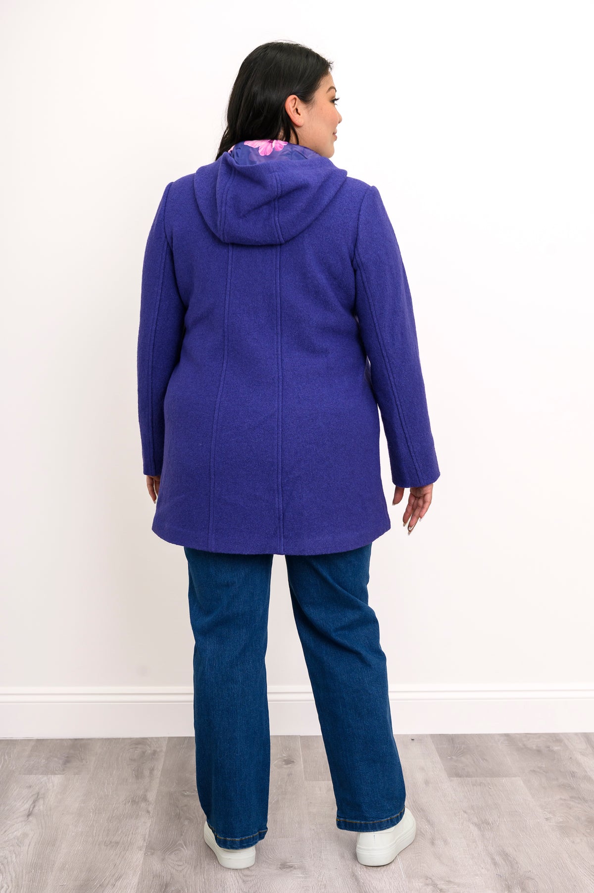 Back view of woman wearing bright purple jacket showing purple floral lining in the hood