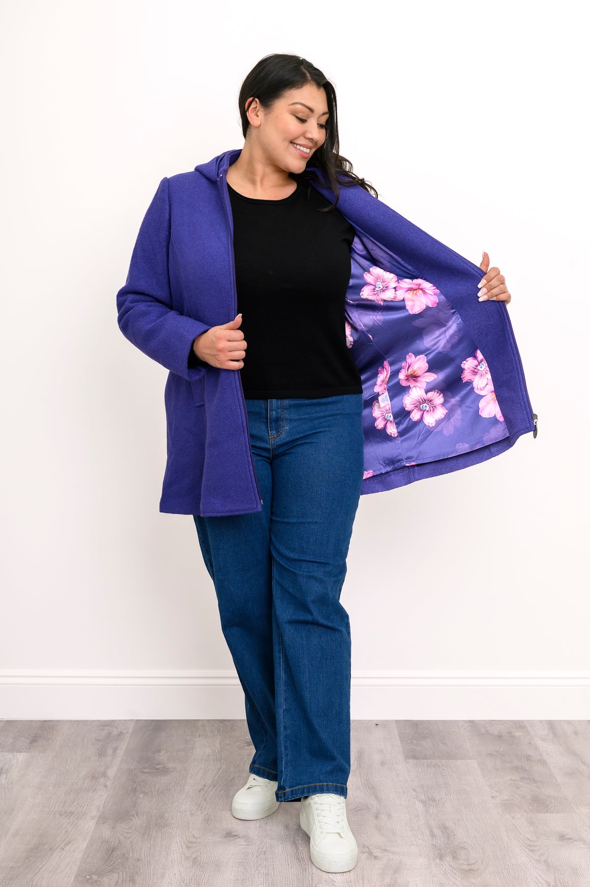 Woman showing off the satin violet and lilac floral lining of her bright purple zip-up jacket