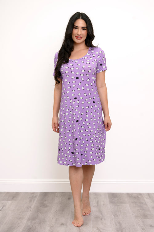 Fully body front view of woman wearing a purple dress with white sheep print