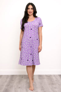 Woman smiling while wearing a purple sheep print sleep dress against a white background