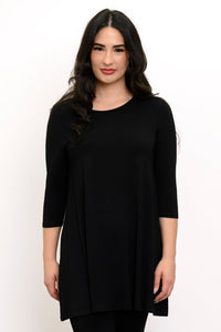 Woman wearing 3/4 sleeve black tunic and black pants against a white background
