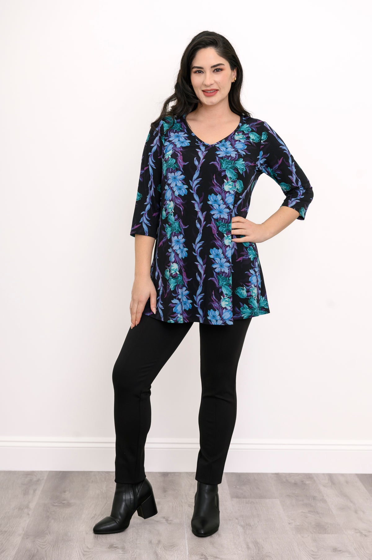 Smiling model in a teal floral patterned bamboo top, showcasing a relaxed fit and flared A-line silhouette.