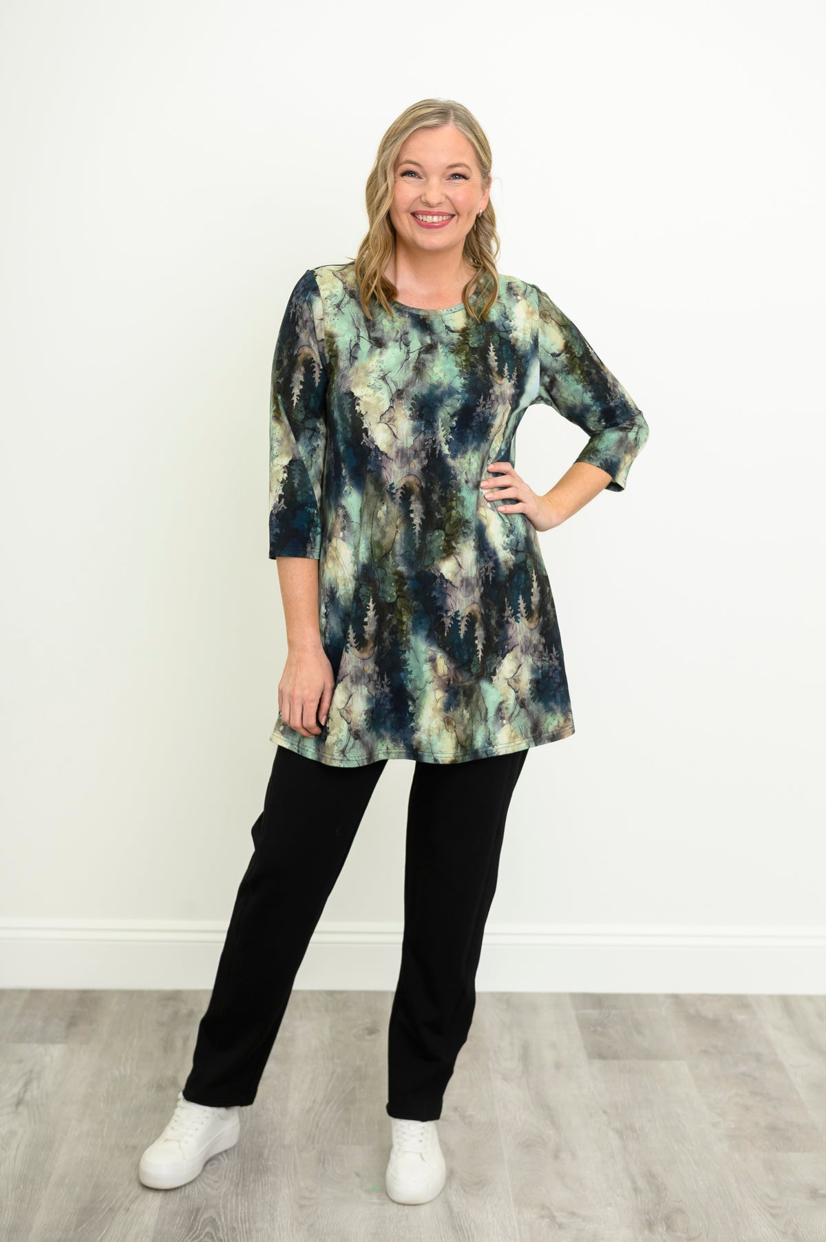 A-line forest pattern knit tunic blouse with 3/4 sleeves, styled with black trousers and white shoes.