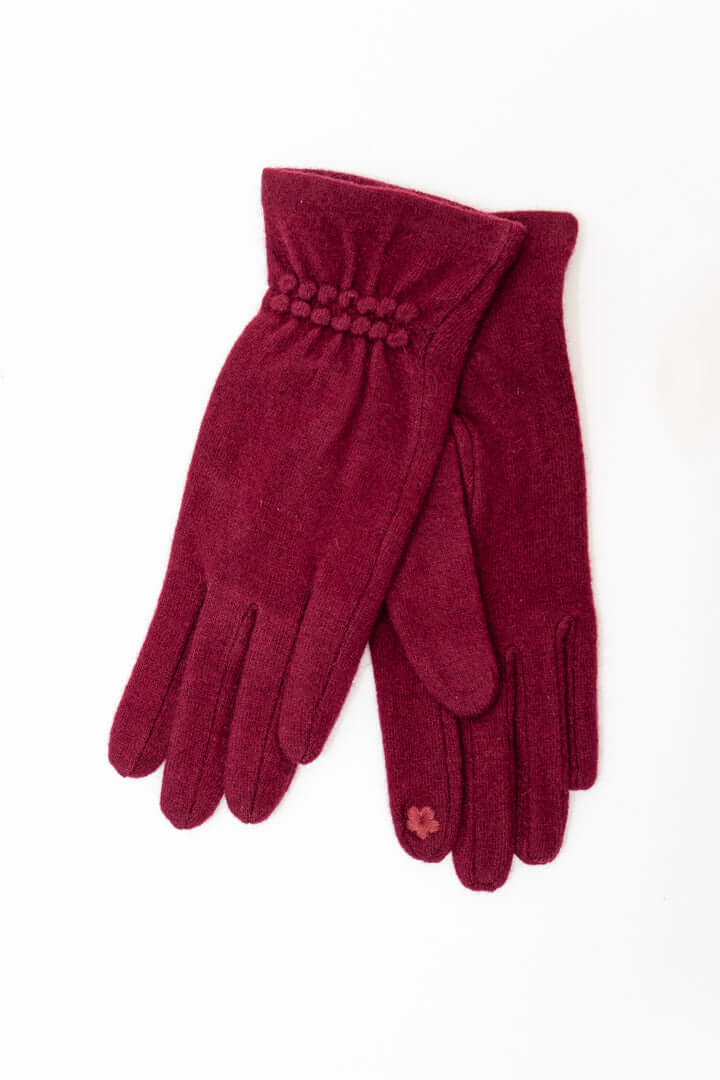A pair of plum-colored wool gloves with textured detailing and a subtle accent on one finger