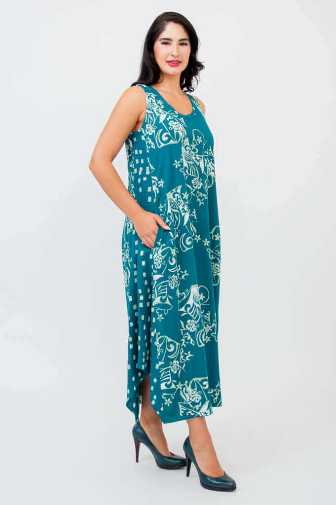 Profile view of woman in teal sleeveless dress with white floral accents and side pockets