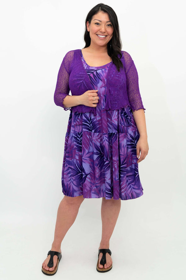 Woman in purple tiered dress with sheer purple cropped cardigan
