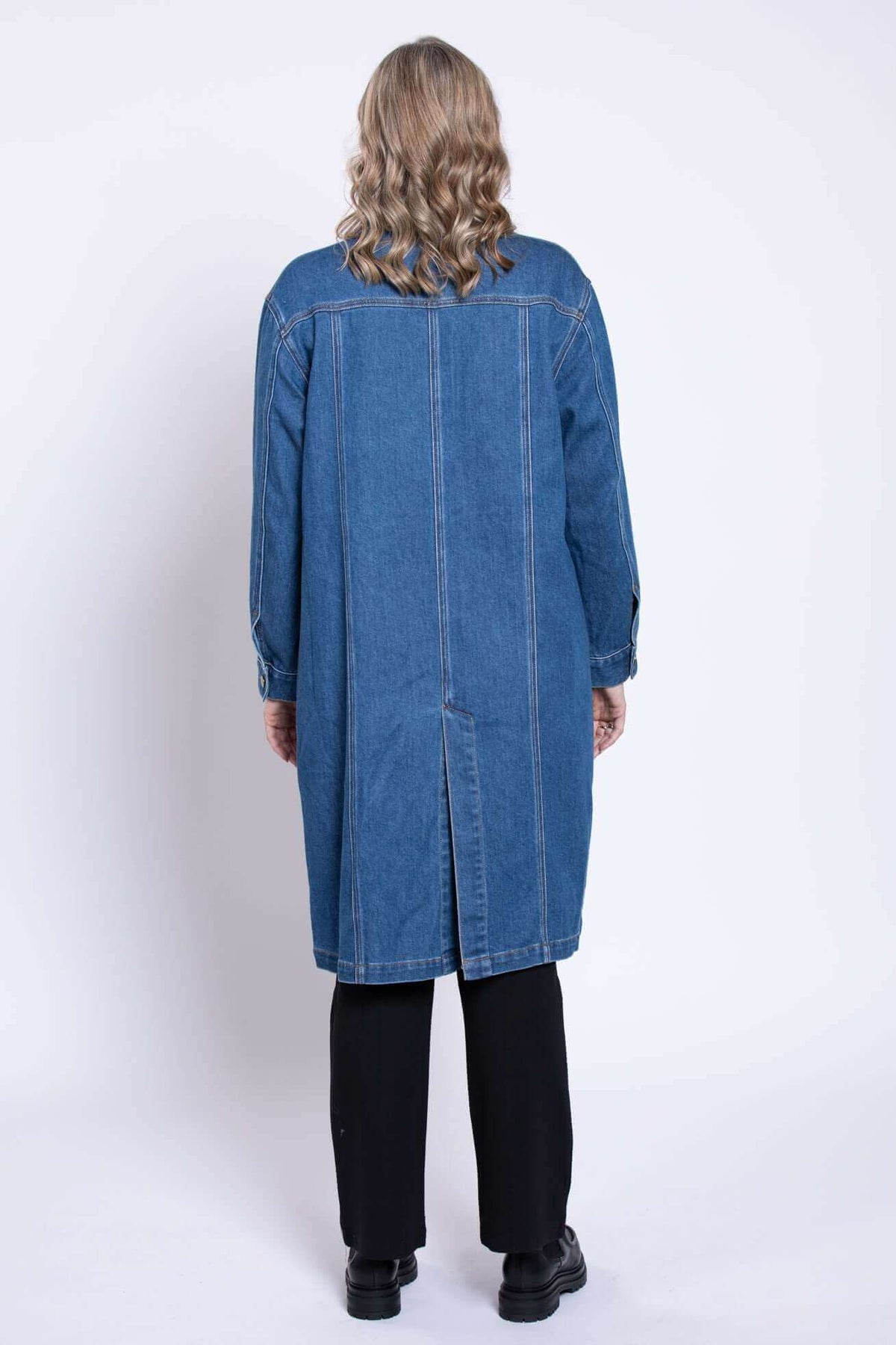 Rear view of Geraldine longline denim jacket worn by model