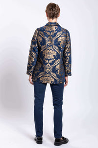 Back view of a woman showing the detailed gold and navy jacquard coat design