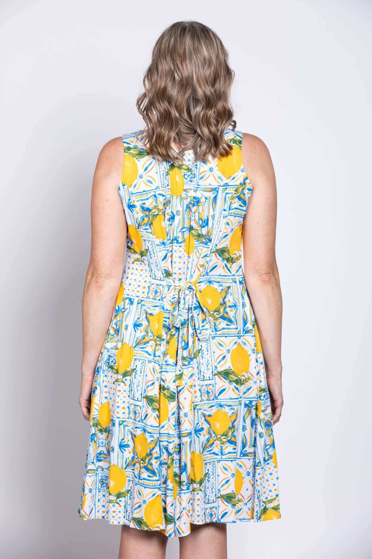 Model wearing Arden dress with tie-back detail, back view