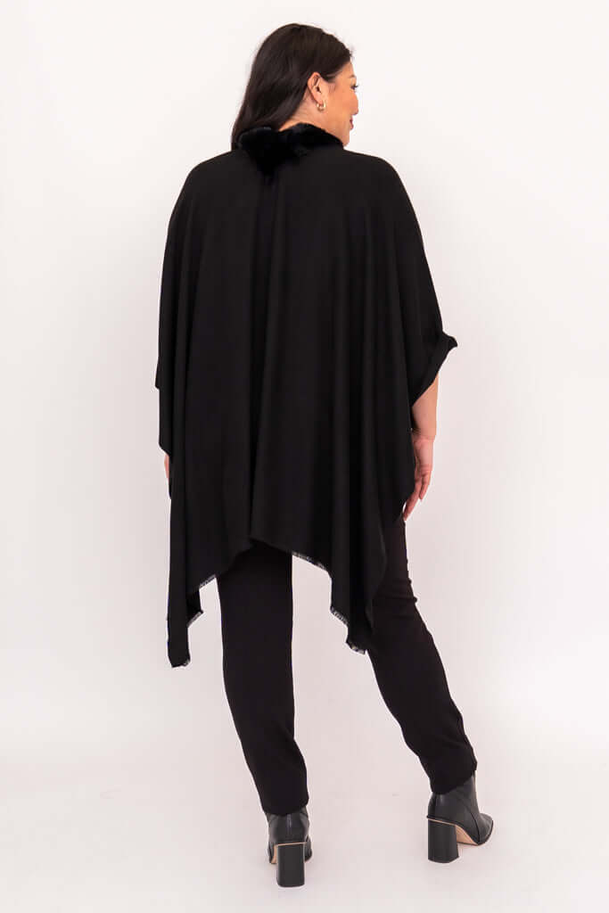 Back view of flowing black wrap worn over pants and boots