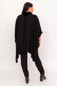 Back view of flowing black wrap worn over pants and boots
