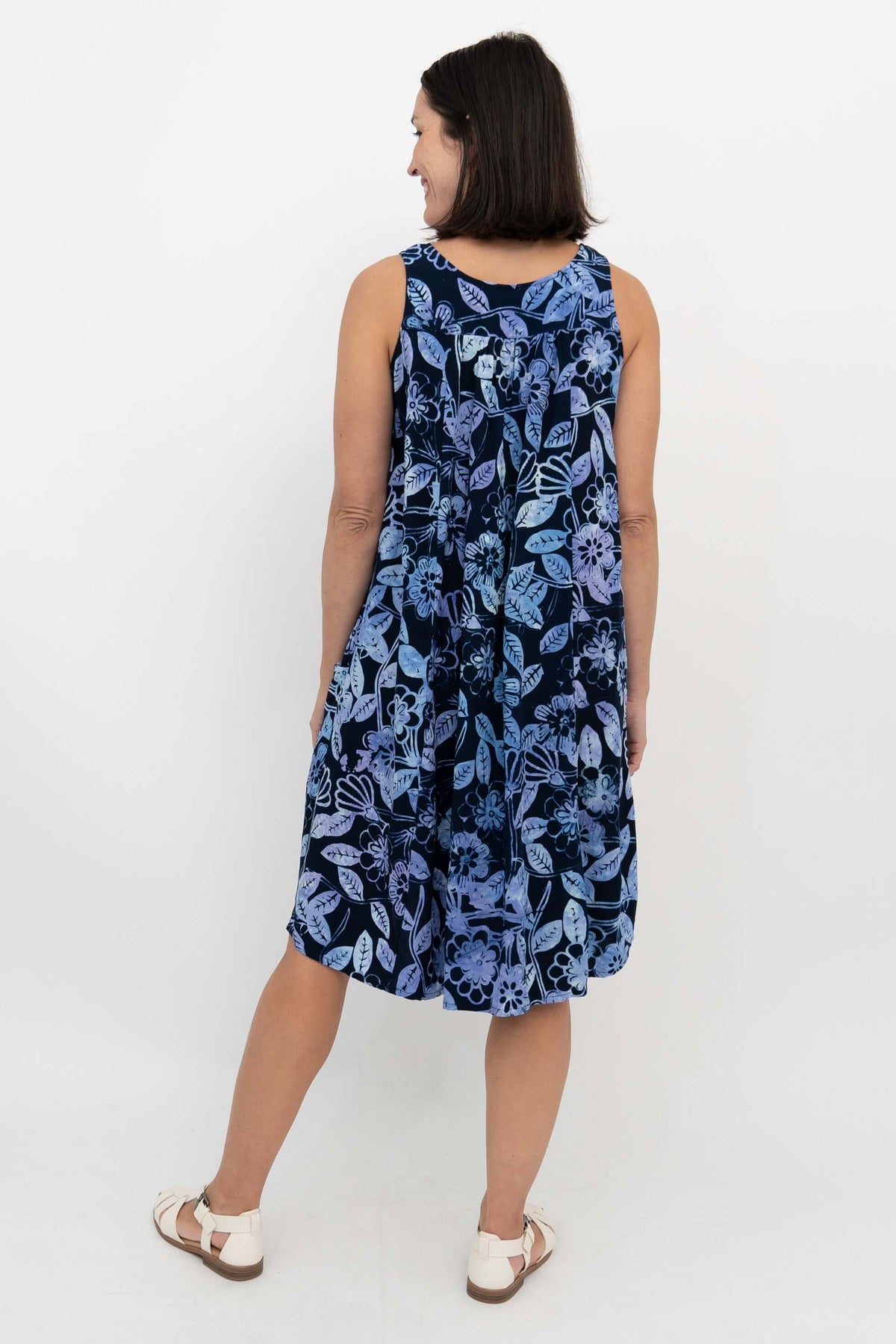 Back view of a woman in a navy blue dress with light blue floral patterns