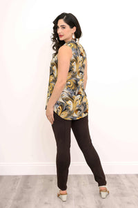 Woman posing in gold and black swirl sleeveless tank, looking over shoulder, rear view