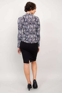 Back view showing the black and white palm print mock neck top paired with a black skirt