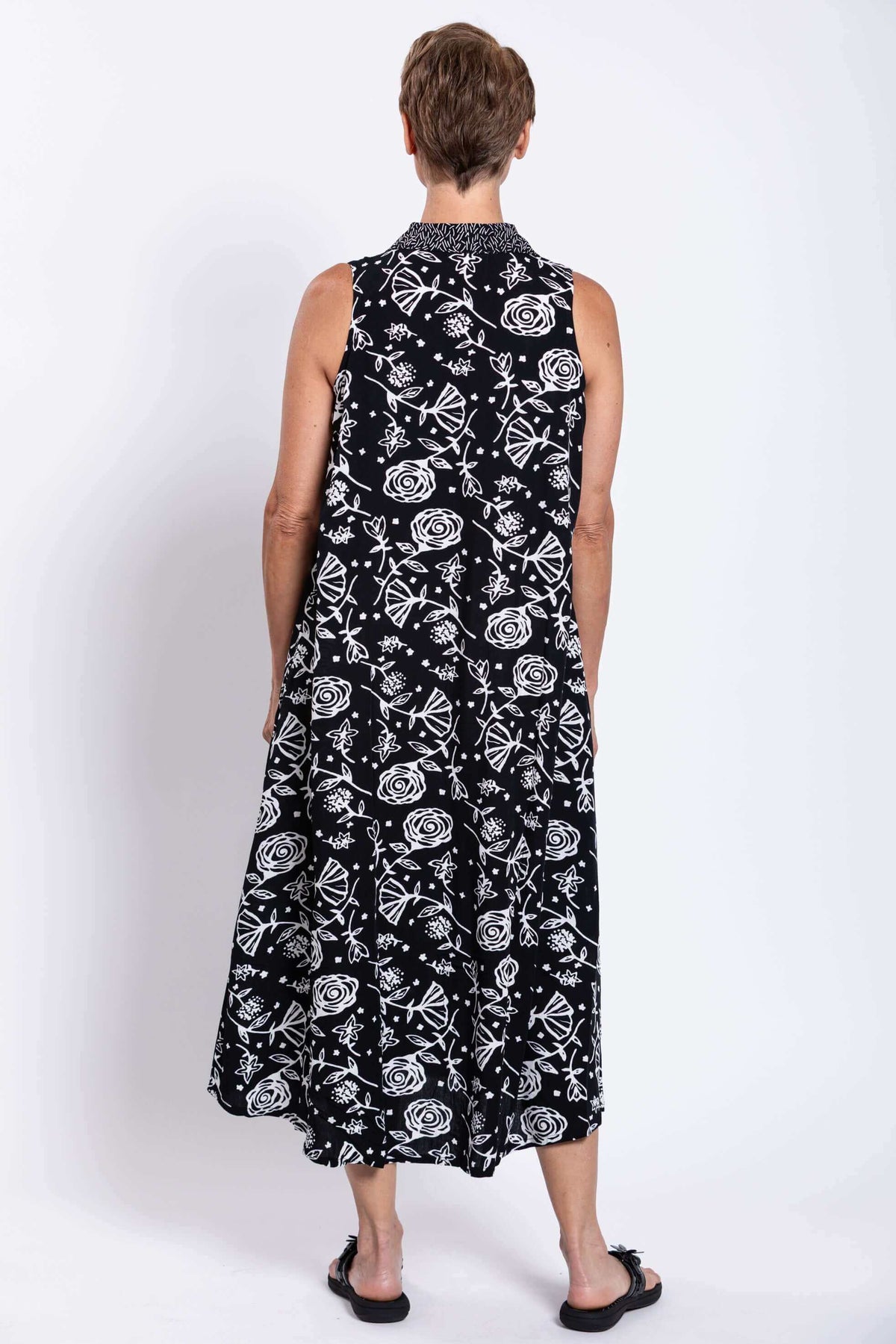 Rear view of sleeveless black and white A-line swing dress on model
