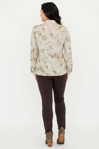 Back view of woman wearing beige floral blouse with brown pants