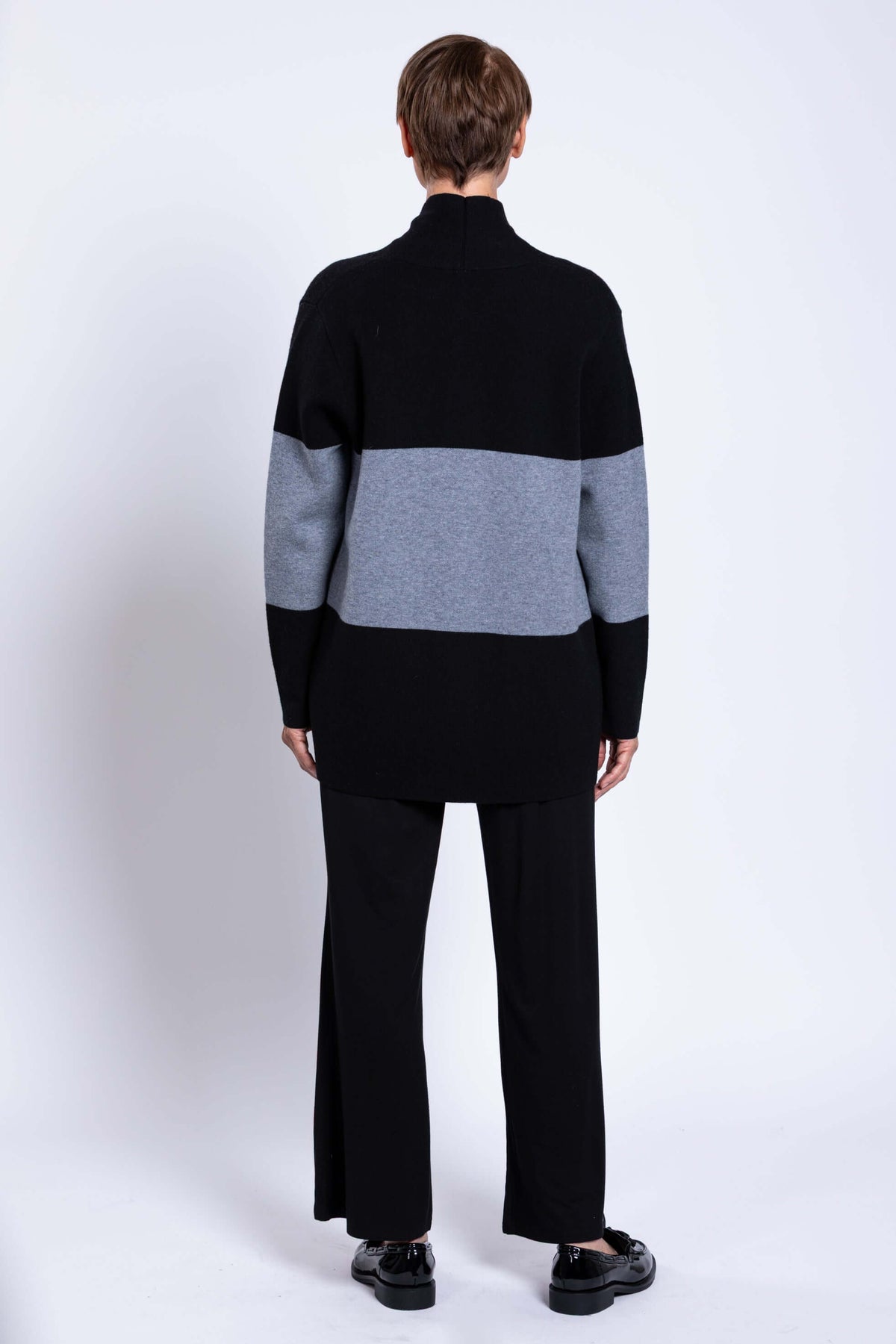 Rear view of woman wearing black and grey colour-block open shawl sweater