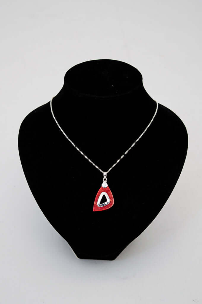Sterling silver necklace with red teardrop pendant displayed on a black jewelry bust