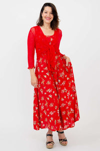 Woman wearing a red floral maxi dress with a matching red tie cardigan