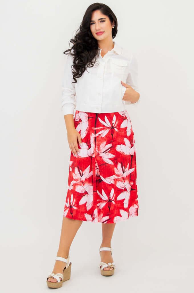 Model in red floral tank dress styled with a white jacket
