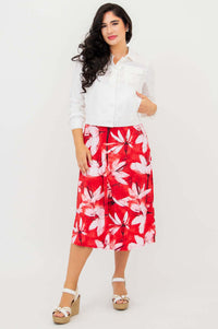 Model in red floral tank dress styled with a white jacket