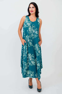 Woman in teal botanical tank dress gazing right, showing relaxed fit and wide straps