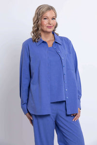 Woman modeling a relaxed azure blue shirt and matching pants, partial front view
