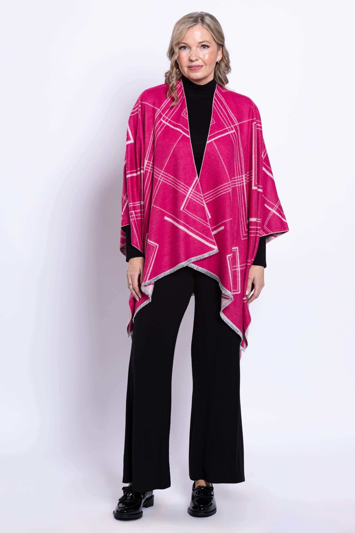 Woman wearing a reversible geometric wrap in fuchsia and pink, full front view