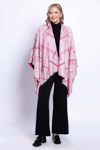 Woman showing the light pink side of a reversible geometric wrap, front view