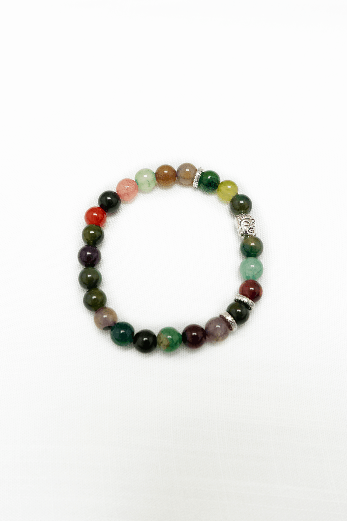 Multi-colored beaded chakra bracelet with a silver Buddha charm on a white background